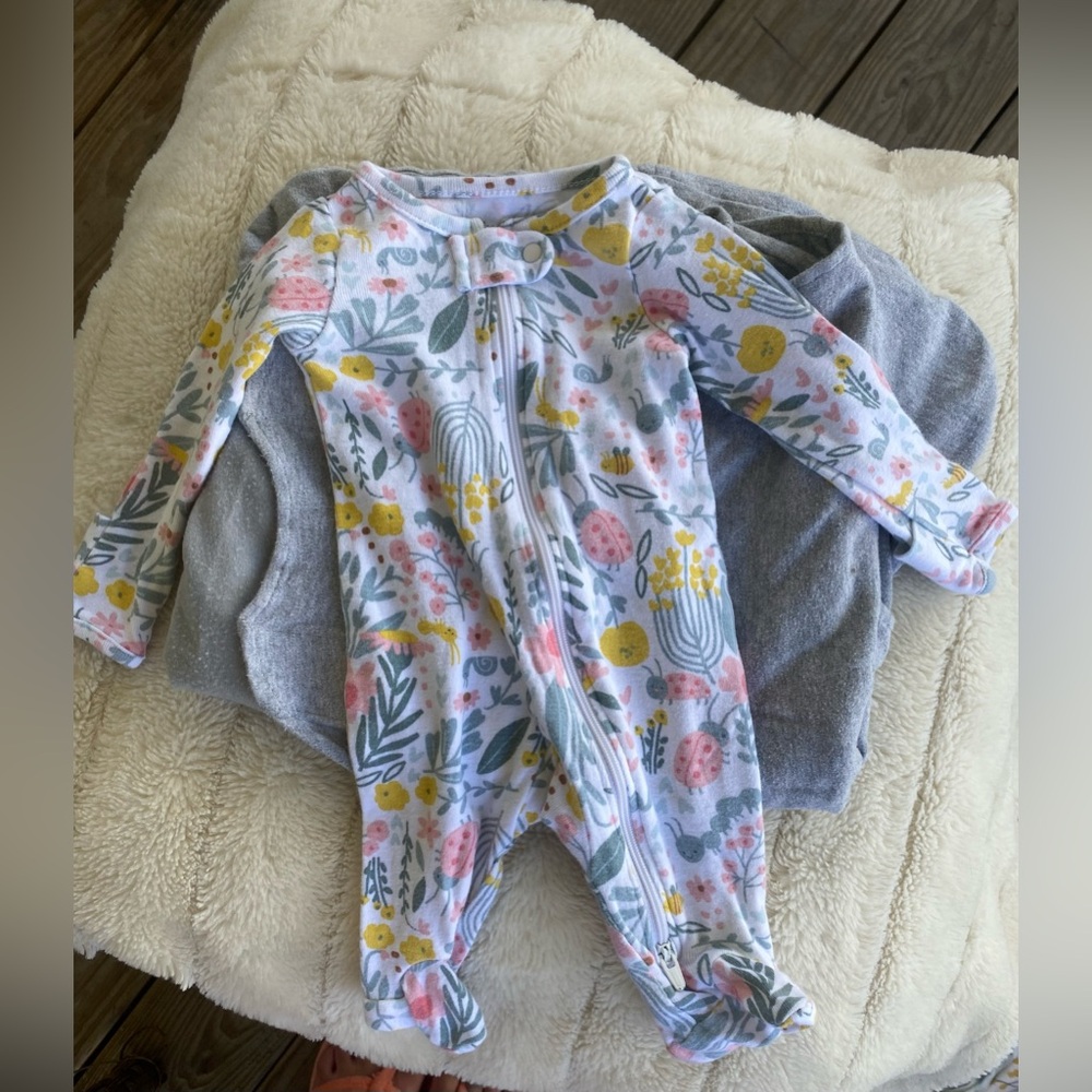 5 used newborn footed pajamas and a portable sound machine.